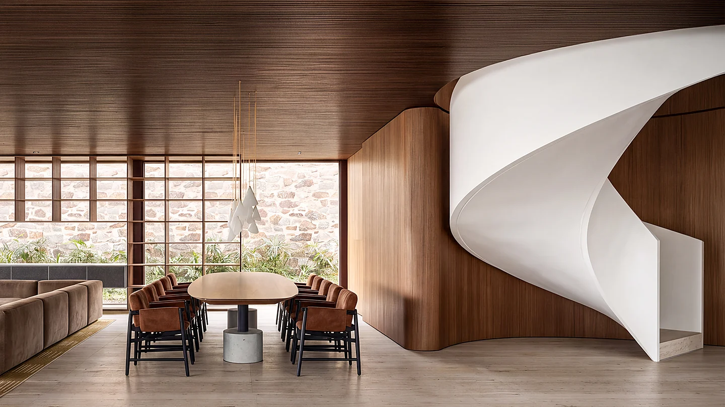Sala de jantar da Casa Maré com escada escultural em espiral e revestimento de madeira
