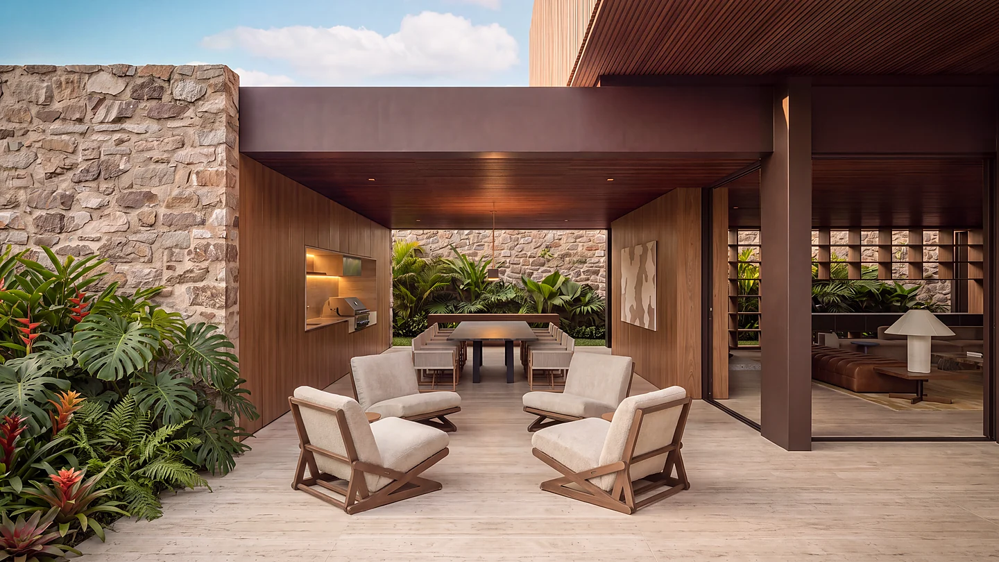 Estar externo coberto da Casa Maré entre parede de pedra e jardim tropical